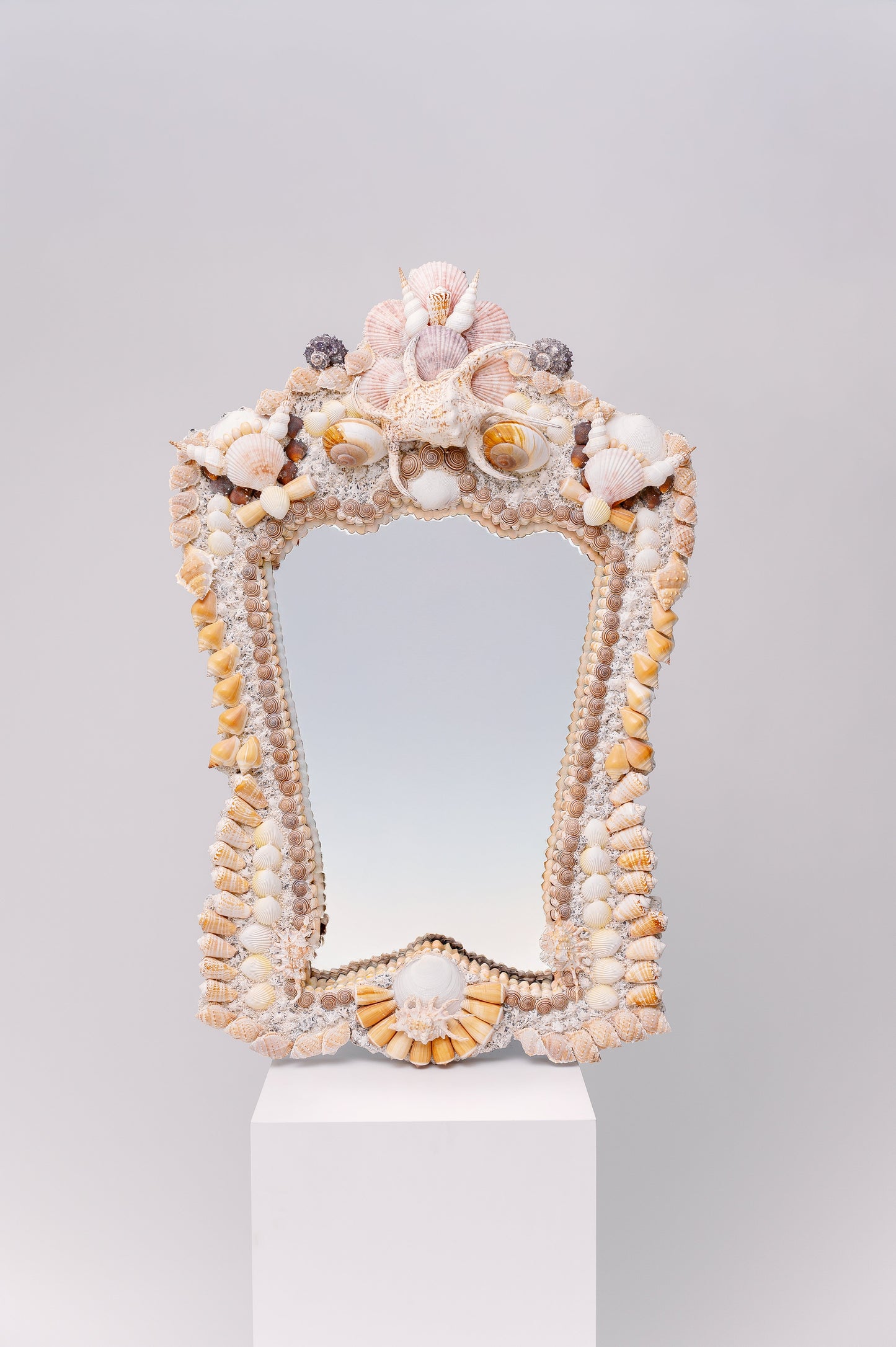 This pair of mirrors has a majestic, regal shape, adorned with a rich arrangement of shells. A perfect addition to your coastal retreat!