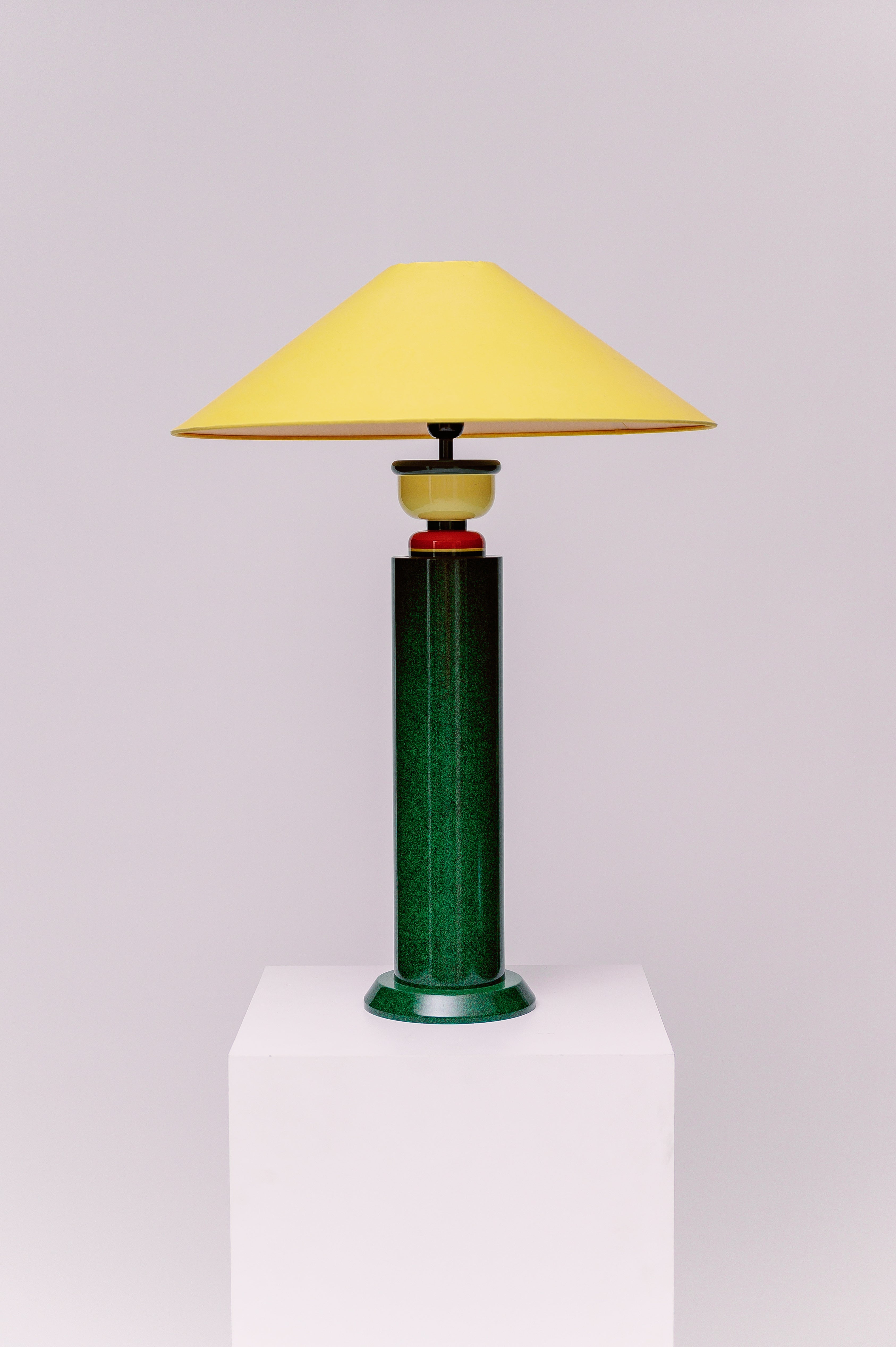 A  1980s French Postmodern high gloss lacquered wood table lamp with a speckled green and black primary color scheme and yellow and red accents.  Sophisticated and mesmerizing!