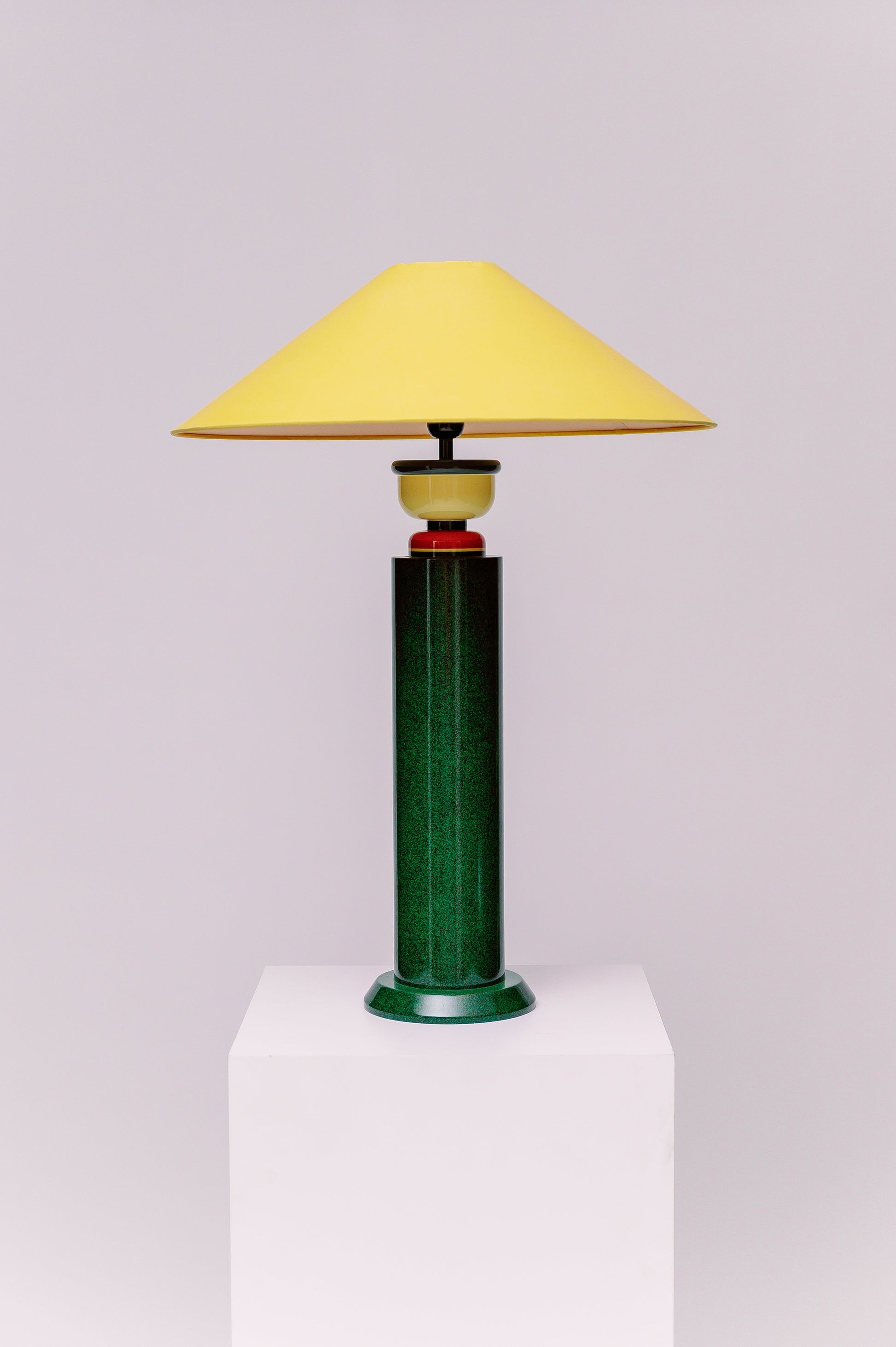 A  1980s French Postmodern high gloss lacquered wood table lamp with a speckled green and black primary color scheme and yellow and red accents.  Sophisticated and mesmerizing!