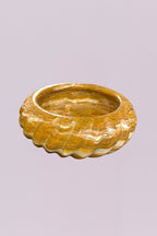 Make a statement with this hand-carved golden onyx marble bowl, featuring striking natural banding and a sculptural scalloped edge. The layered tones of warm amber, cream, and soft gold create a one-of-a-kind pattern, giving this piece depth and movement from every angle.