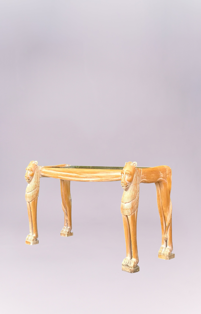 The Regal Sentinel Console Table is a magnificent statement piece that blends the majesty of the wild with classical elegance. This striking table is defined by its two expertly carved lion figures, which form the front legs and support the tabletop with powerful, stoic presence.