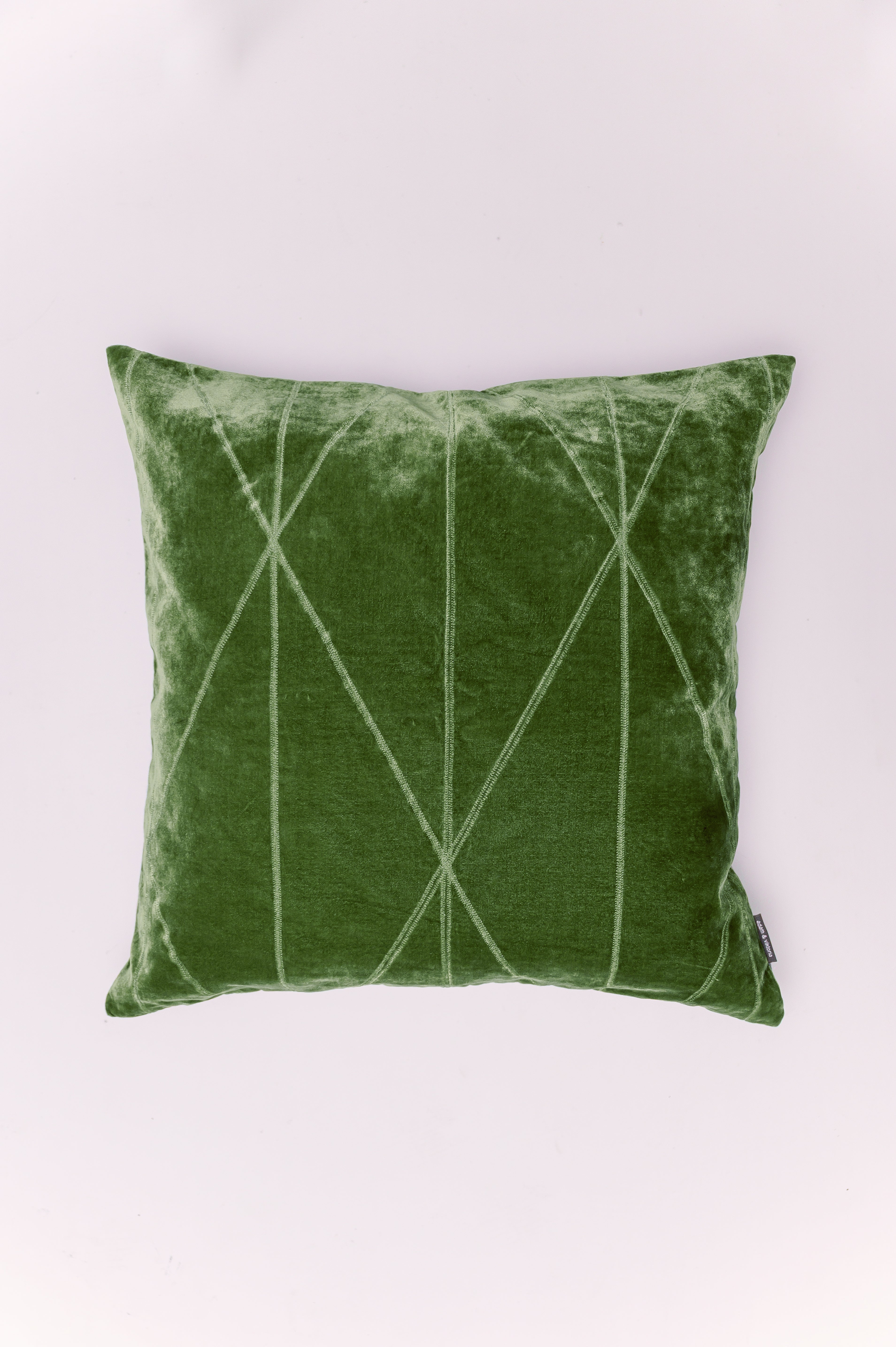 Introduce depth and luxury to your space with The Emerald Lattice Pillow. Crafted from plush, shimmering crushed velvet in a vibrant, jewel-toned emerald green, this piece is a true statement maker. The design is subtly enhanced by a clean, stitched geometric pattern that creates an elegant, diamond-like grid. This delicate contrast of texture and line adds a modern architectural touch to the pillow's vintage-inspired glamour. It's the perfect way to add a sophisticated pop of color and rich texture to a so