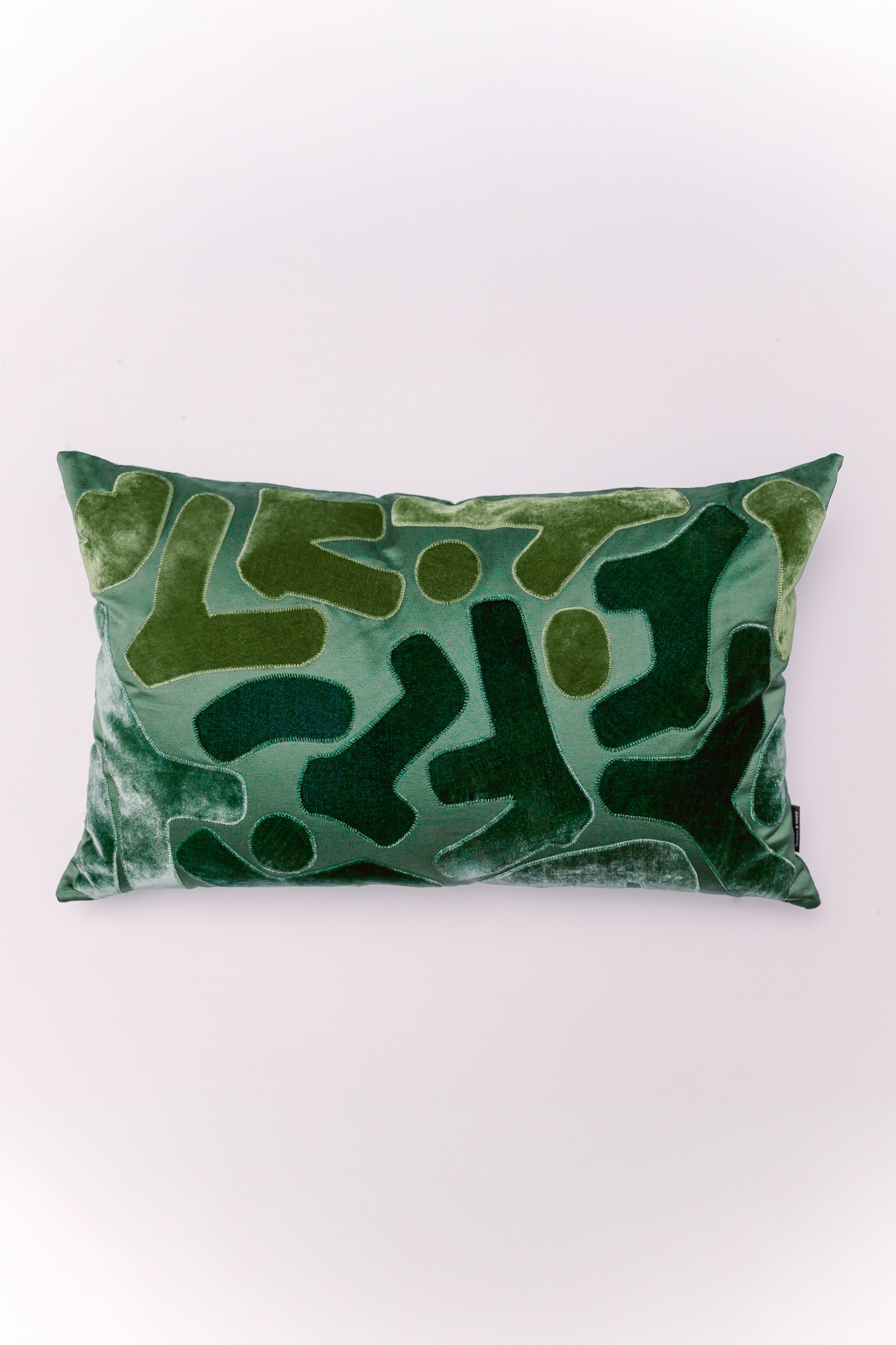 The Emerald Mosaic Lumbar is a textural masterpiece designed to elevate any space. Crafted from plush, shimmering emerald green velvet, this pillow features an intricate, tone-on-tone pattern created through detailed appliqué and stitching. The varying shades of green, from dark jade to bright teal, and the mix of soft velvet with a more structured, stitched fabric, create a rich, three-dimensional effect. Its elongated shape is ideal for providing stylish support and a designer finish to armchairs, benches