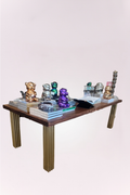 Handmade dining table, featuring a rich wood top with intricate carved detailing and elegant brass legs. 