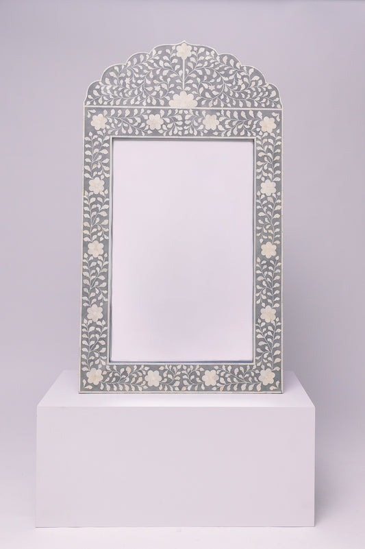 This mirror has an elegant, floral inlay with a soft scalloped arch that gives it a refined and timeless feel.