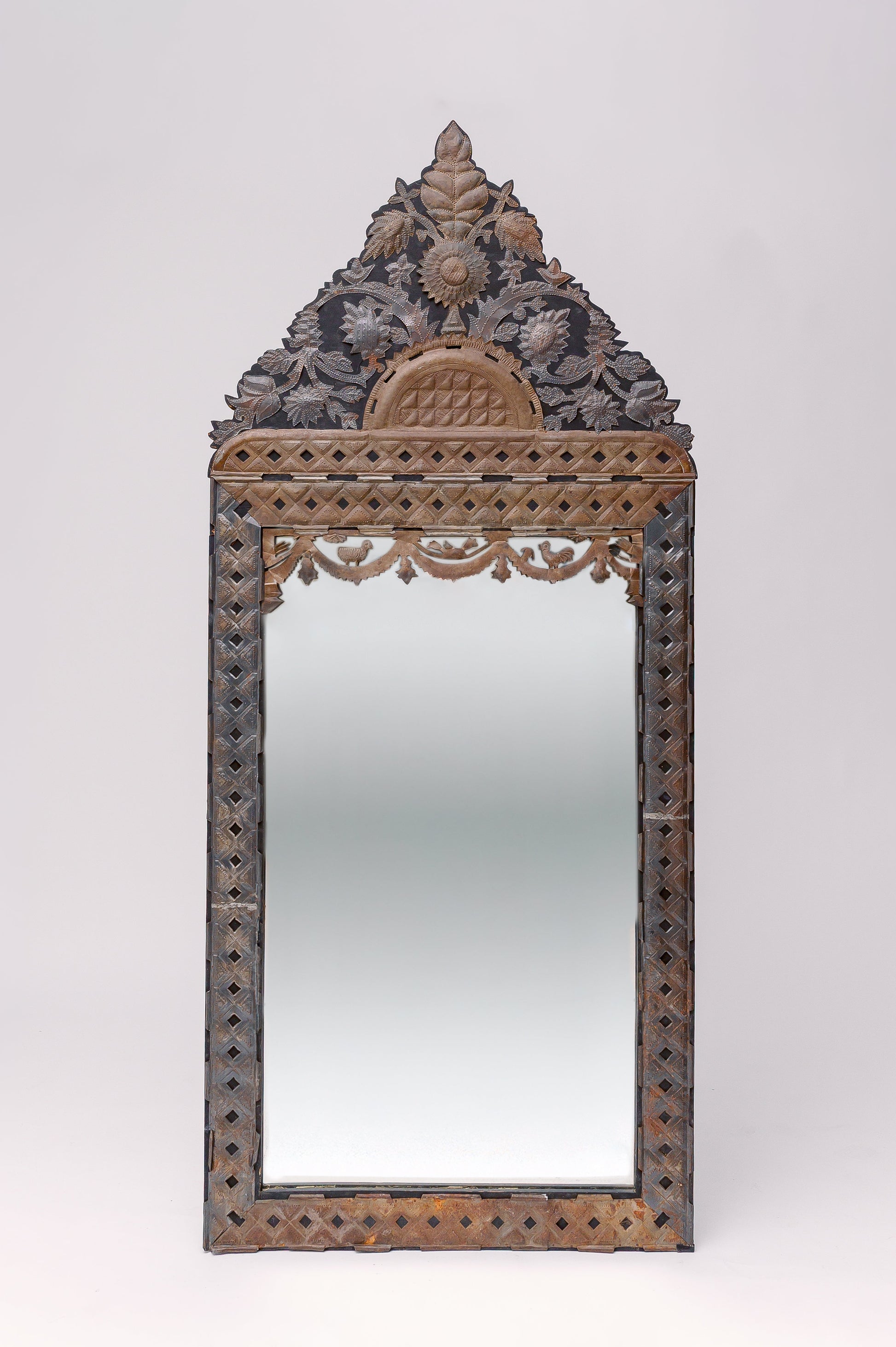 Translating to "the ancient vine", this large tin adorned mirror features intricate carvings of florals, animals and geometric shapes.
