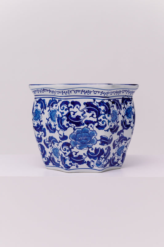 This elegant hand-painted porcelain planter features a classic cobalt blue floral and foliate motif on a crisp white ground. The scrolling peony design is traditional to Chinese export porcelain and symbolizes prosperity, honor, and good fortune. The vessel’s wide mouth and gently flared form make it ideal as a decorative jardinière, cachepot, or centerpiece.