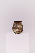 A heavy, small-scale stone vase featuring deep chocolate tones and dramatic white veining. Its rounded, classic silhouette brings a sense of weight and sophisticated history to any shelf or mantel.