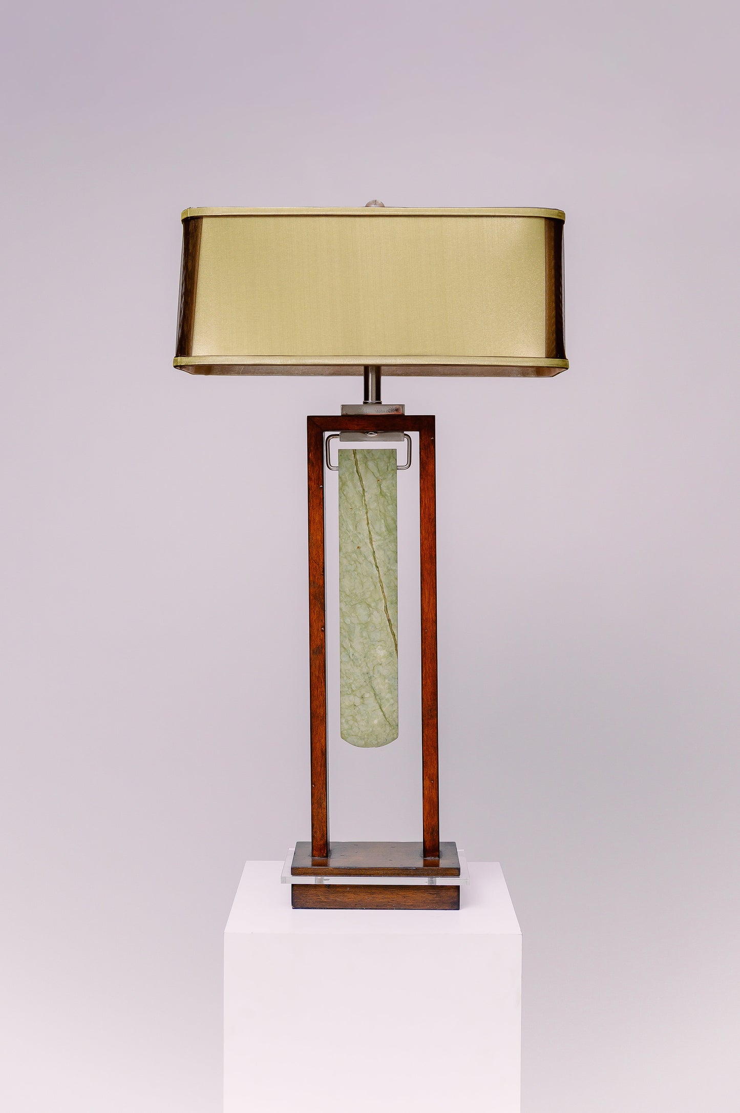 Two light table lamp - rectangular mahogany finished frame with clear lucite accent and a blade shaped piece of green jade stone suspended at the center like a pendulum.