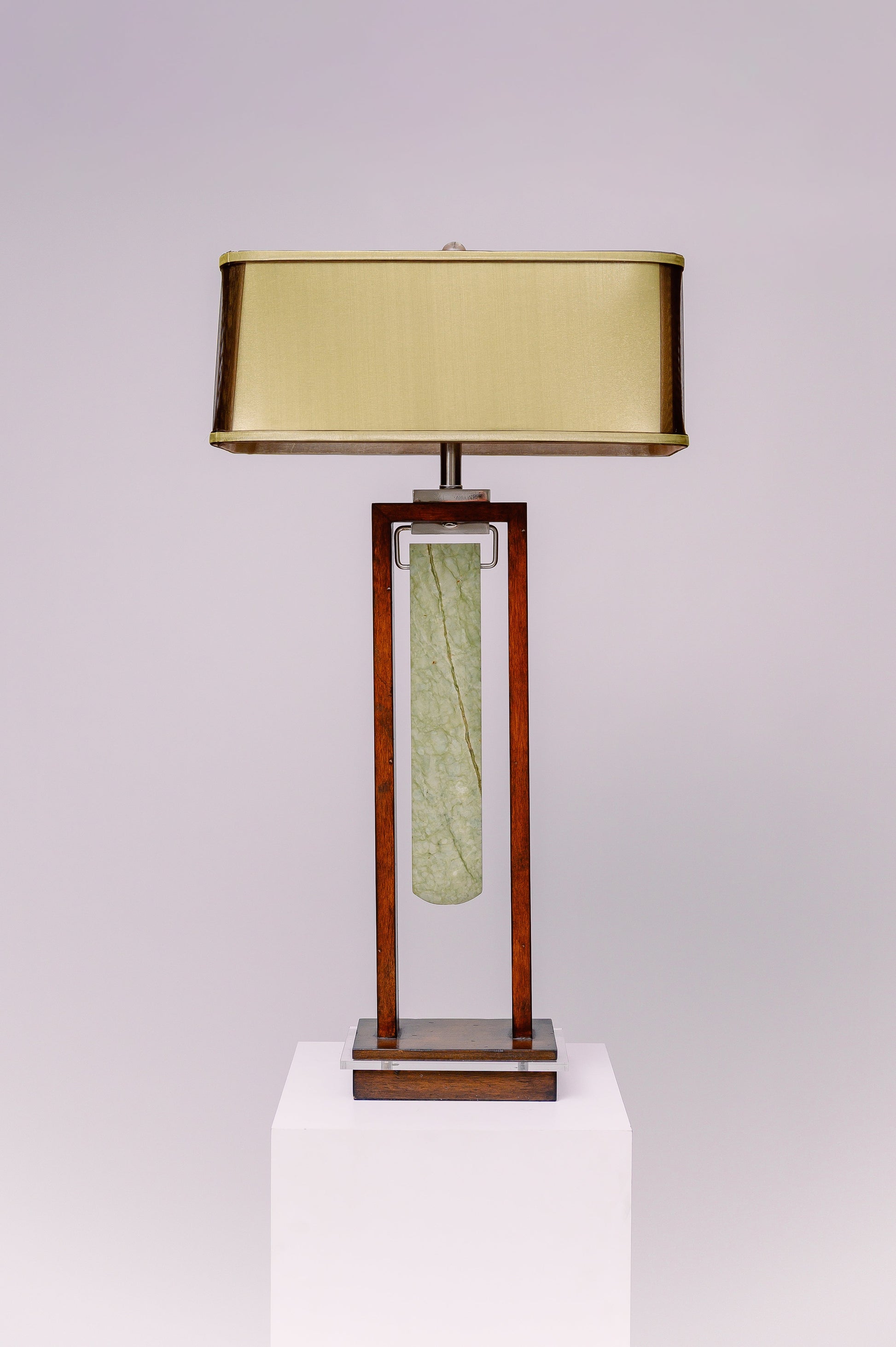 Two light table lamp - rectangular mahogany finished frame with clear lucite accent and a blade shaped piece of green jade stone suspended at the center like a pendulum.