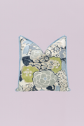 A sophisticated square pillow featuring a large-scale, painterly floral design in cool, calming tones of soft sage green, dove gray, deep navy, and light powder blue. It is elegantly finished with light blue contrast piping for a classic, refined look.