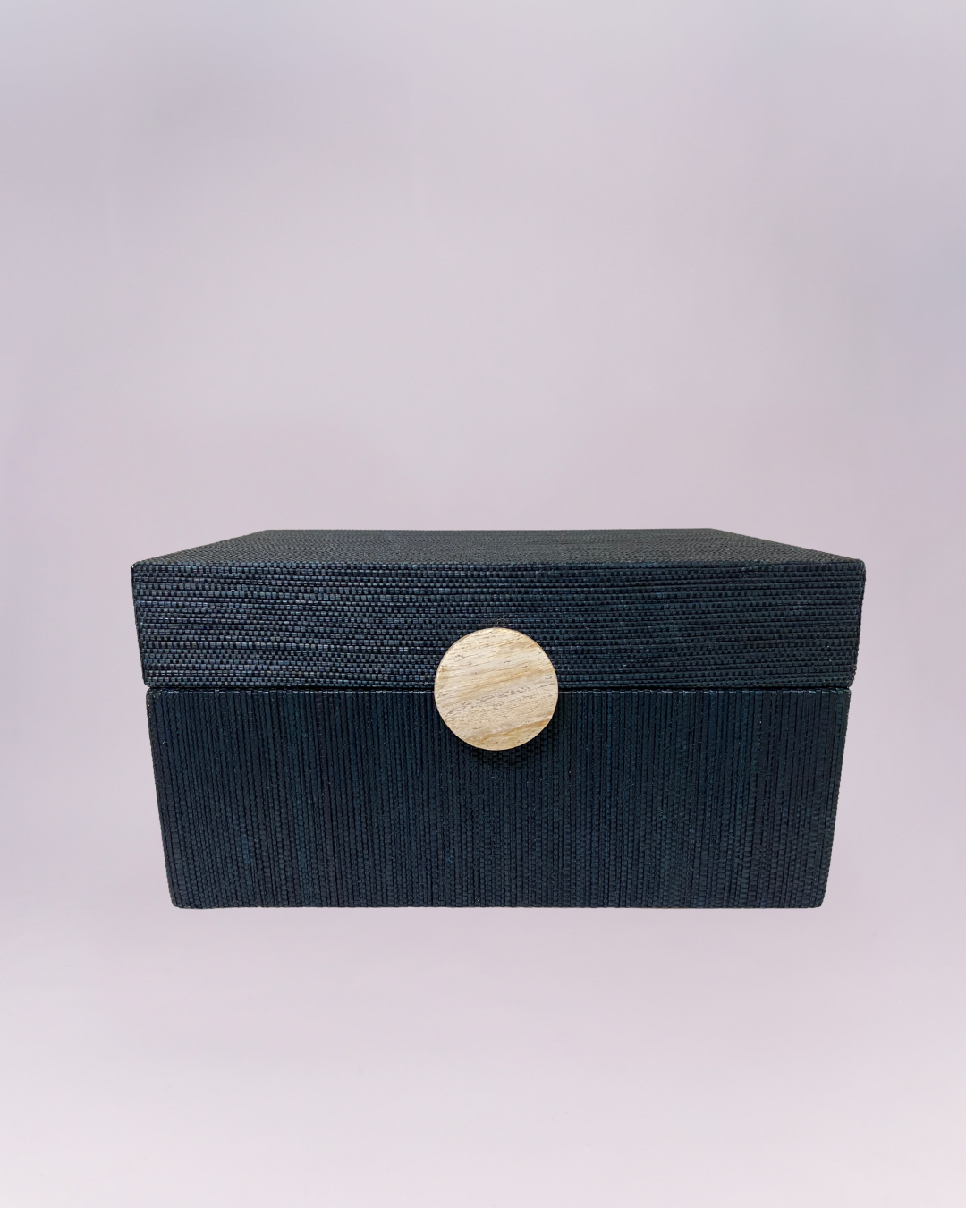 Elevate your home organization with this elegant navy blue grasscloth box. The exterior is wrapped in a finely woven natural fiber that provides a rich, tactile finish, perfectly contrasted by a round, cream-colored bone or light wood medallion at the center. Its clean lines and deep indigo hue make it a versatile accent for coastal, transitional, or modern interiors.