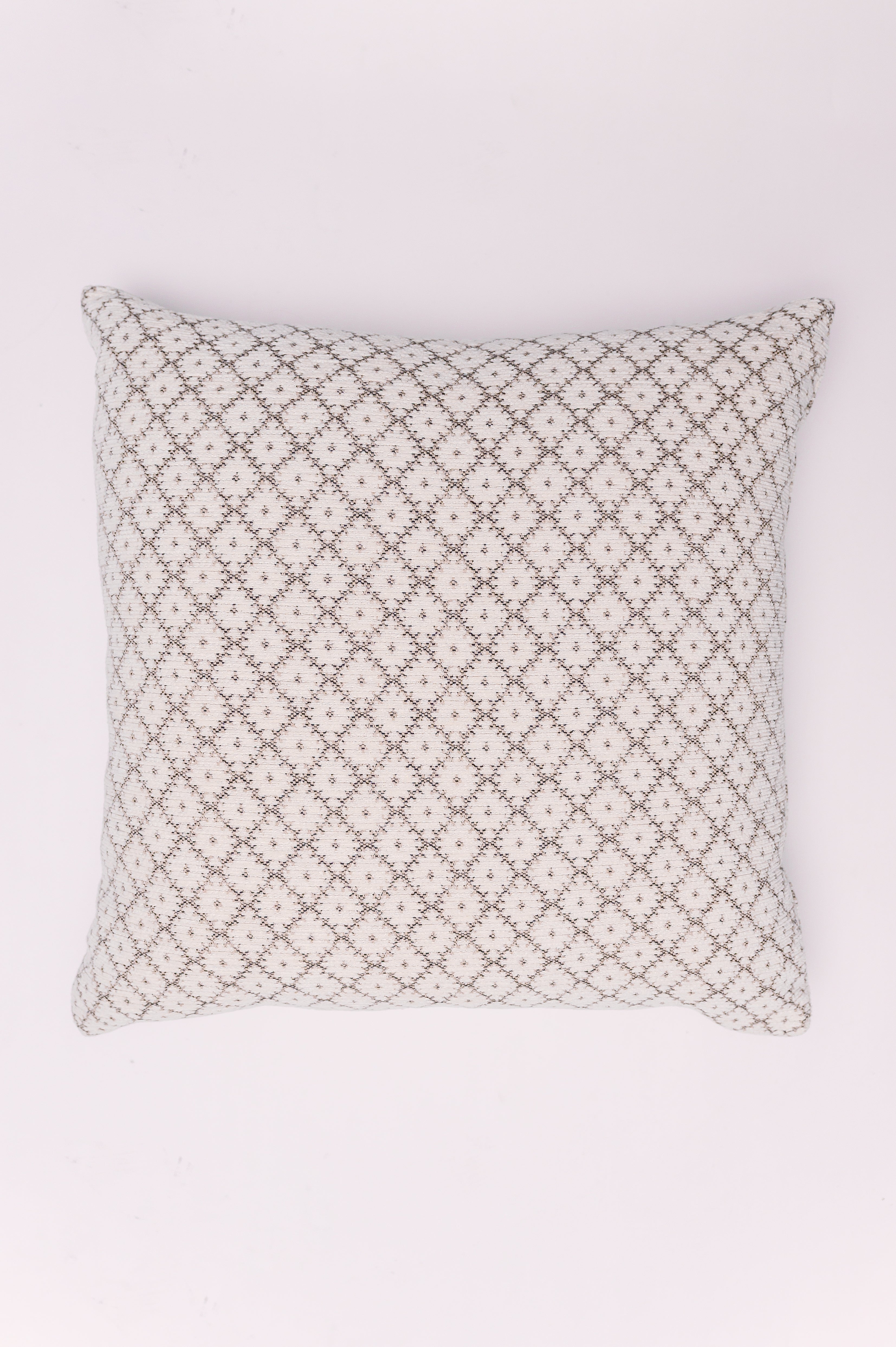 Add subtle texture and cozy sophistication to your space with The Nordic Diamond Pillow. This piece features a delicately woven diamond or lattice pattern created through a soft, tonal texture. The overall color palette is a neutral blend of creamy white and muted taupe or light grey, giving it a warm, inviting, and highly versatile appeal. The raised, textured weave gives the pillow a cozy, handcrafted feel, perfect for layering with solid colors or other patterns. 