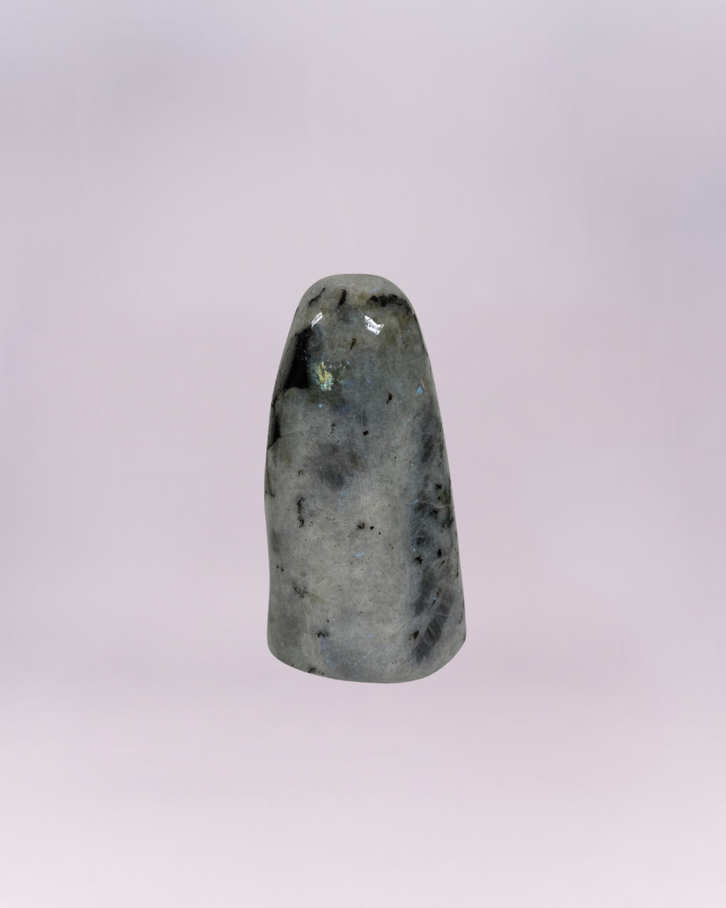 This is a smooth, free-standing accent piece cut and polished into a rounded, dome-topped obelisk or tower shape. A natural stone, featuring a blend of white, gray, and black speckling and veining.