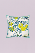 A fresh, vibrant outdoor-style pillow featuring stylized yellow citrus fruits and blossoms among lush navy and teal leaves on a white ground. The crisp light blue piping adds a final touch, making it perfect for a sunroom or patio.