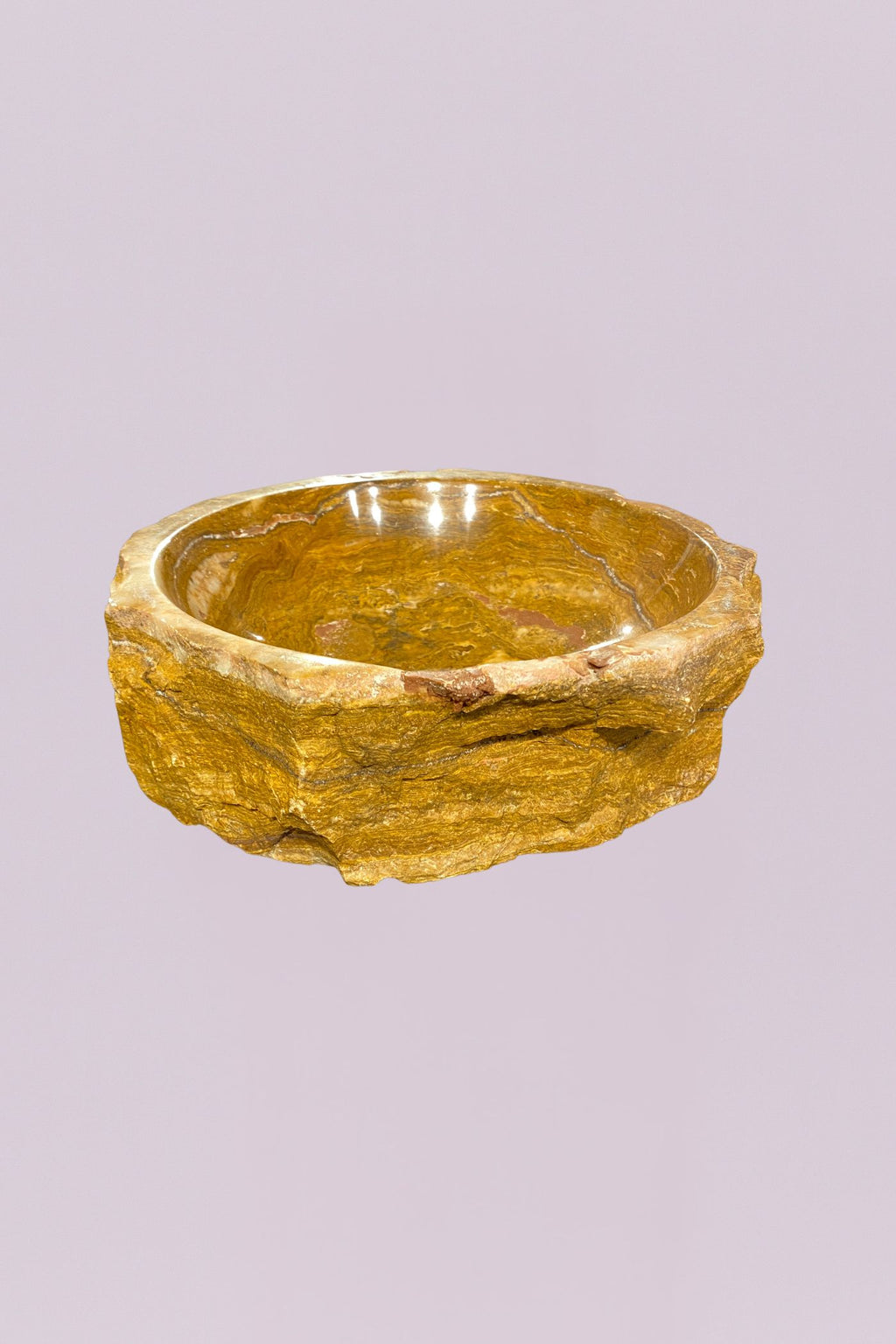 Bring a grounded, organic feel to your space with this raw edge golden onyx marble bowl. Carved from solid stone, this piece highlights the natural beauty of layered mineral formations, with rich golden tones, soft cream veining, and subtle variations that make it entirely one of a kind.
