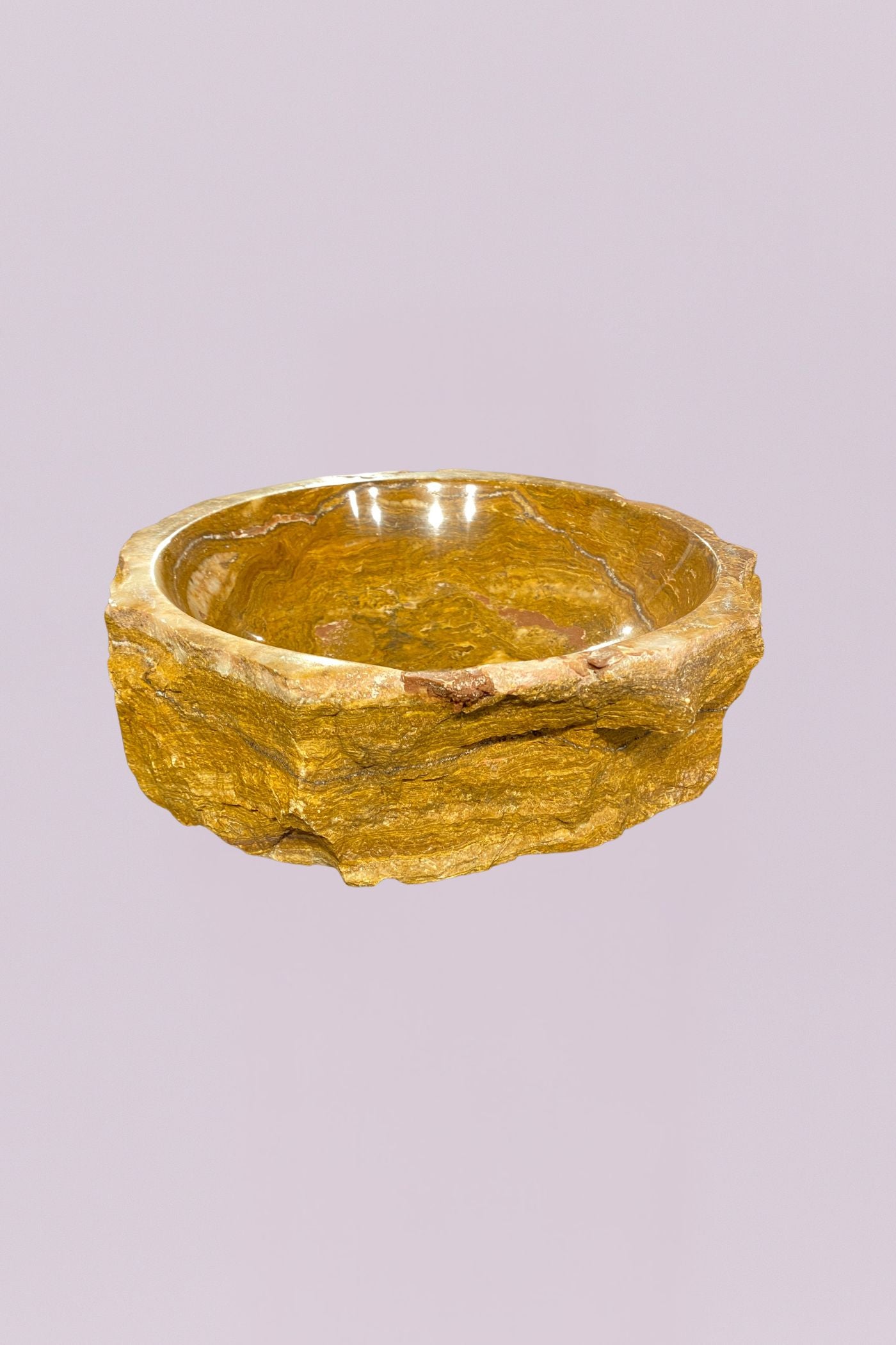 Bring a grounded, organic feel to your space with this raw edge golden onyx marble bowl. Carved from solid stone, this piece highlights the natural beauty of layered mineral formations, with rich golden tones, soft cream veining, and subtle variations that make it entirely one of a kind.