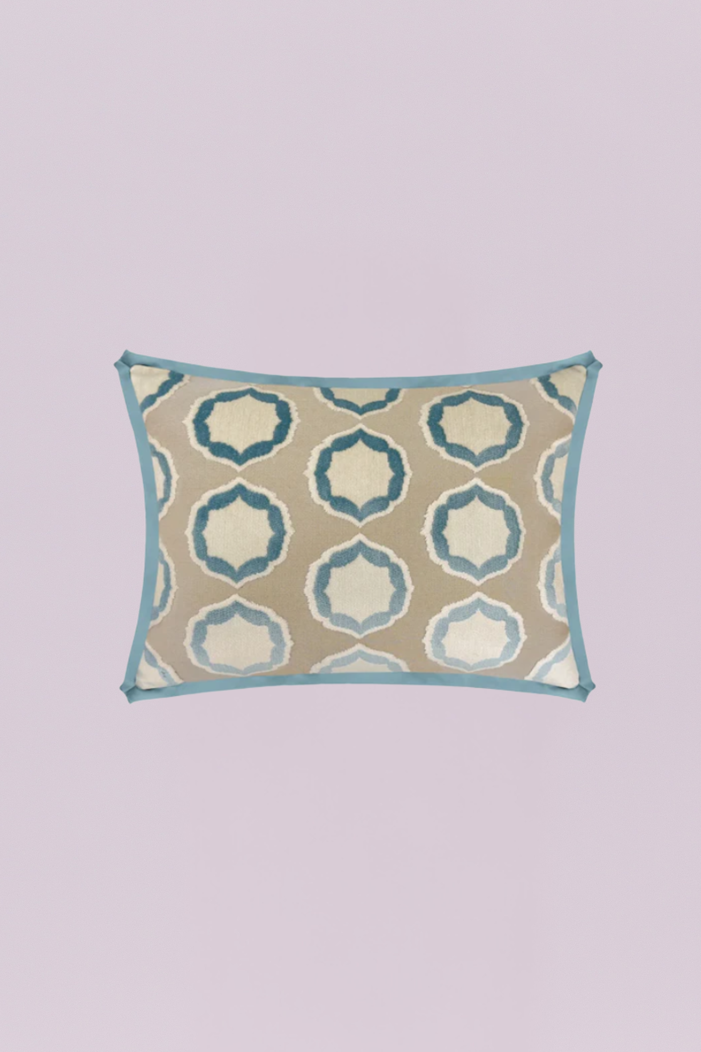 This elegant rectangular pillow features a plush, woven geometric ogee pattern in shades of soft blue and ivory on a warm taupe background. The design is neatly framed by a bold, tailored light blue piping, offering a chic global and contemporary feel.
