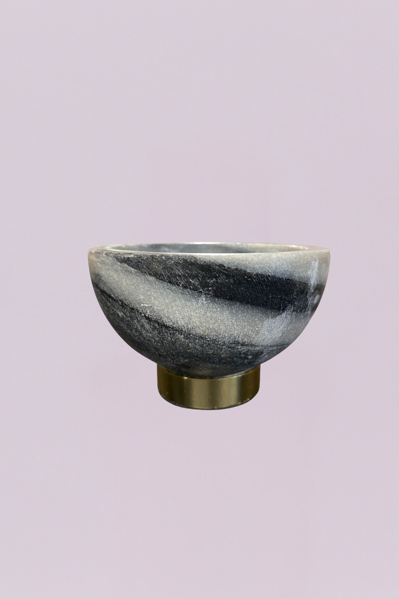 This elegant decorative bowl features a striking natural marble body with high-contrast grey and white veining. The organic, swirling patterns of the stone are beautifully offset by a clean, cylindrical base finished in a warm, brushed brass. Its compact scale makes it a sophisticated accent for smaller surfaces.