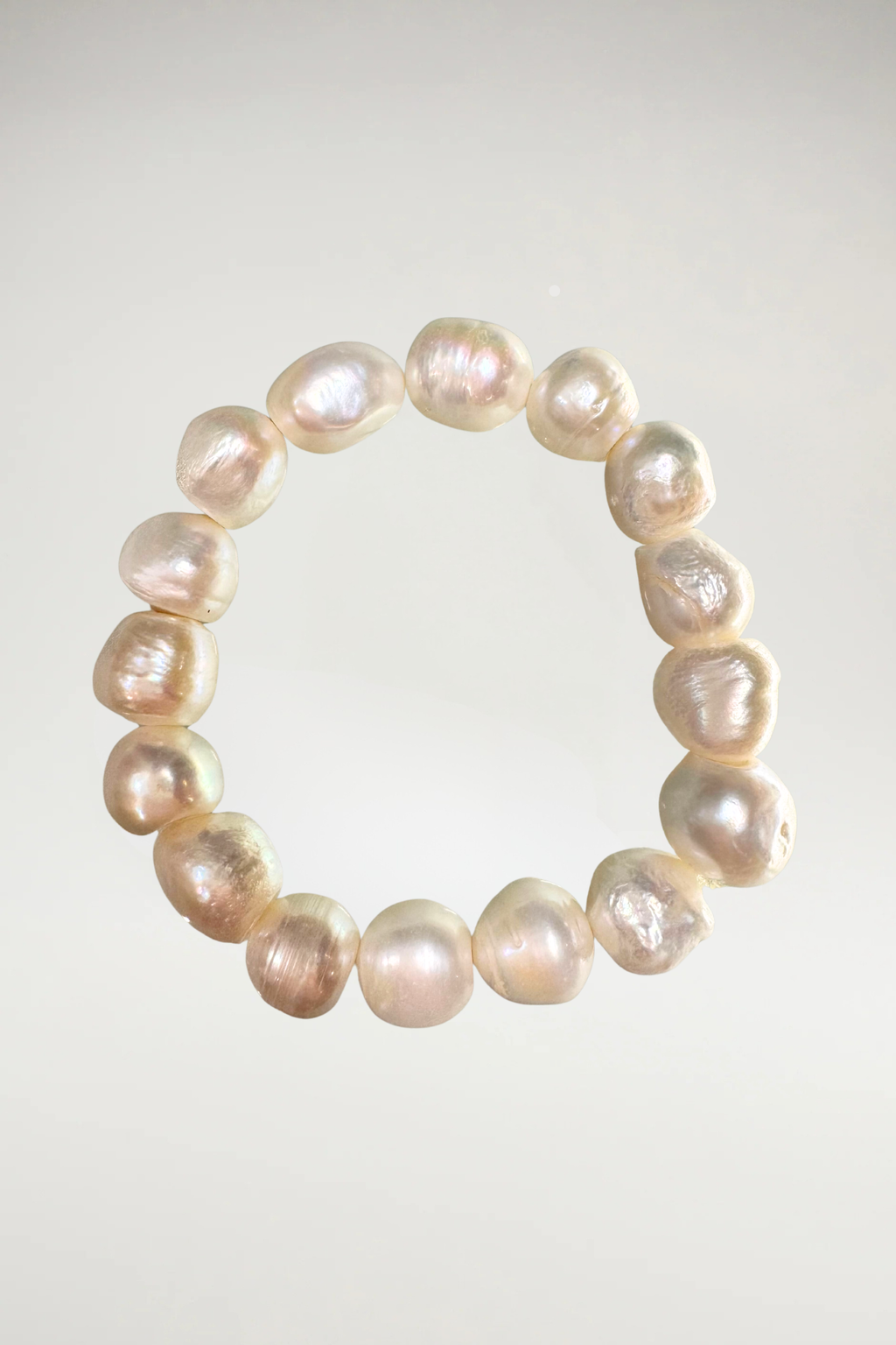 Indulge in the striking warmth and modern elegance of this breathtaking creamy white pearl statement bracelet. Composed of exceptional, large-scale cultured pearls, this piece commands attention with its substantial presence and an extraordinarily rare, high-shine metallic finish.
