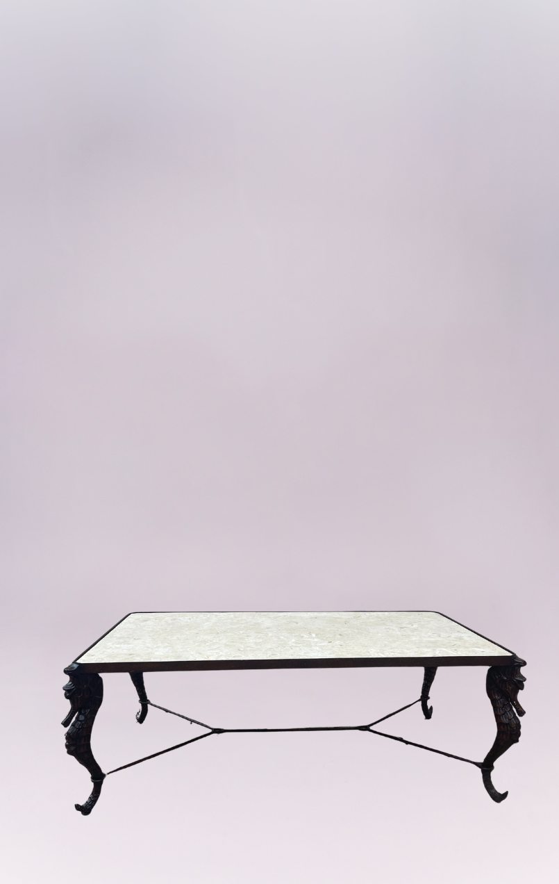 This elegant coffee table features a polished cream limestone top set on a sculptural black base. The intricately carved seahorse legs lend a distinctive coastal-meets-classic charm, while the iron cross-stretcher provides both balance and durability. A statement piece that blends artistry and function beautifully.