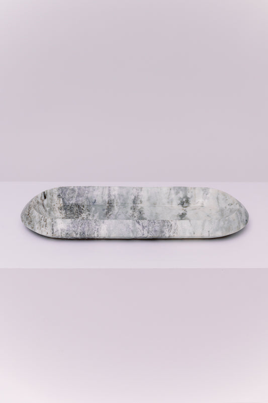 This exquisite oval tray is more than just an object; it is a whisper of history captured in stone. Carved from genuine marble, its luminous shades of grey and white swirl together in patterns as fluid as a river. This piece invites you to slow down, to feel its smooth, cool weight, and to find beauty in its natural veining. Let it become the anchor for your most cherished items—a tranquil home for your jewelry, a showcase for candles, or a stylish resting place for your daily essentials.