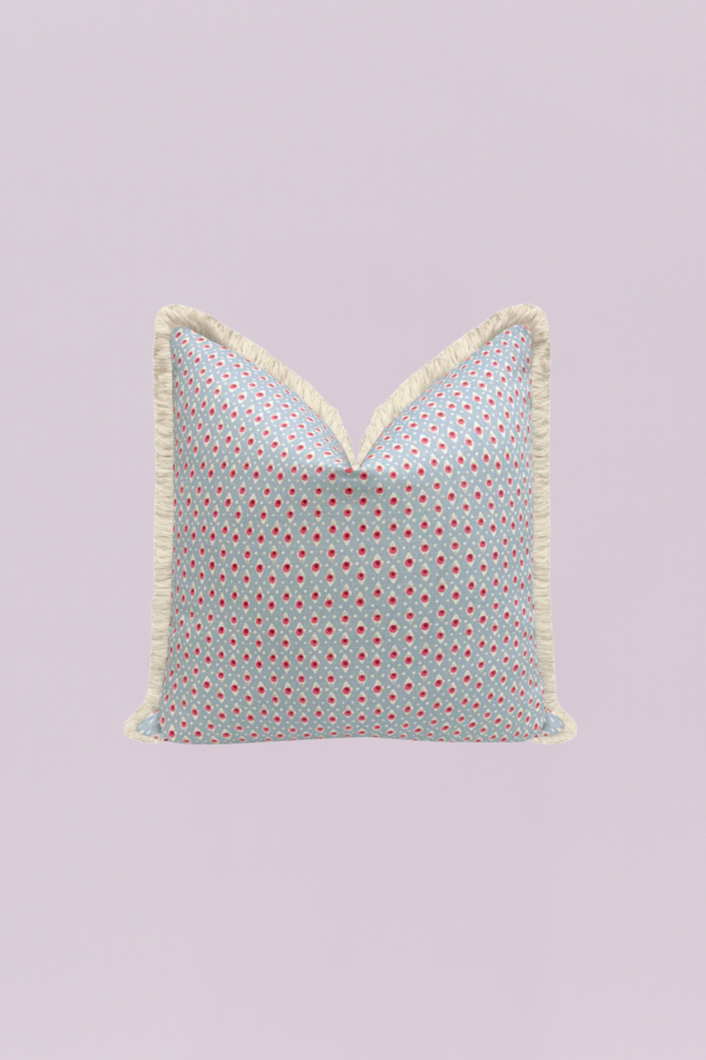 This delightful accent pillow features a playful, delicate dot pattern in pink and reddish-pink on a soft, powder blue background. The whimsical design is framed by a generous, natural ivory-colored fringe, adding a cozy, bohemian-inspired texture to its vintage charm.