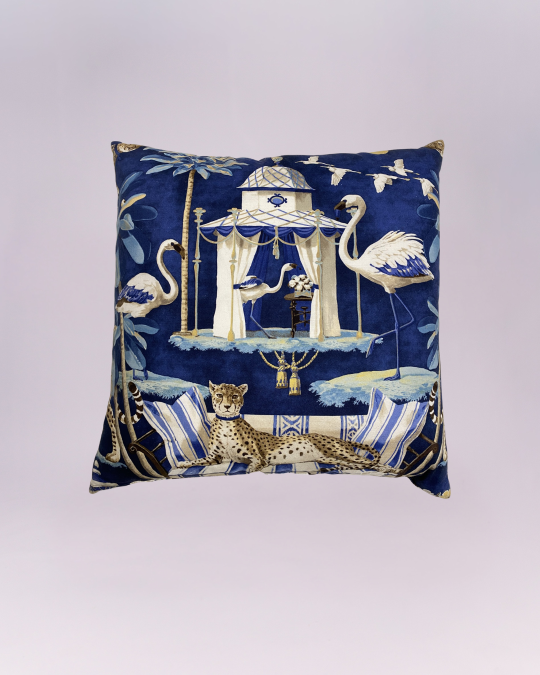 Elevate your space with this luxurious cobalt blue velvet pillow, featuring a whimsical and sophisticated "Grand Tour" aesthetic. The detailed illustration depicts a regal cheetah lounging on a striped settee, set against a backdrop of elegant flamingos and a classical garden pavilion.