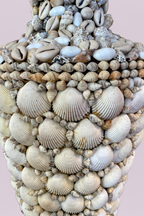 Decorative bust covered in seashells on a pink background