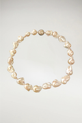 A majestic strand of oversized champagne baroque pearls. While The Eloise leans into cool, silvery-white tones, The Beatrice offers a warmer, more sun-kissed glow with deep honey and cream undertones. This piece is finished with a matching gold magnetic orb clasp to complement its rich, golden luster.