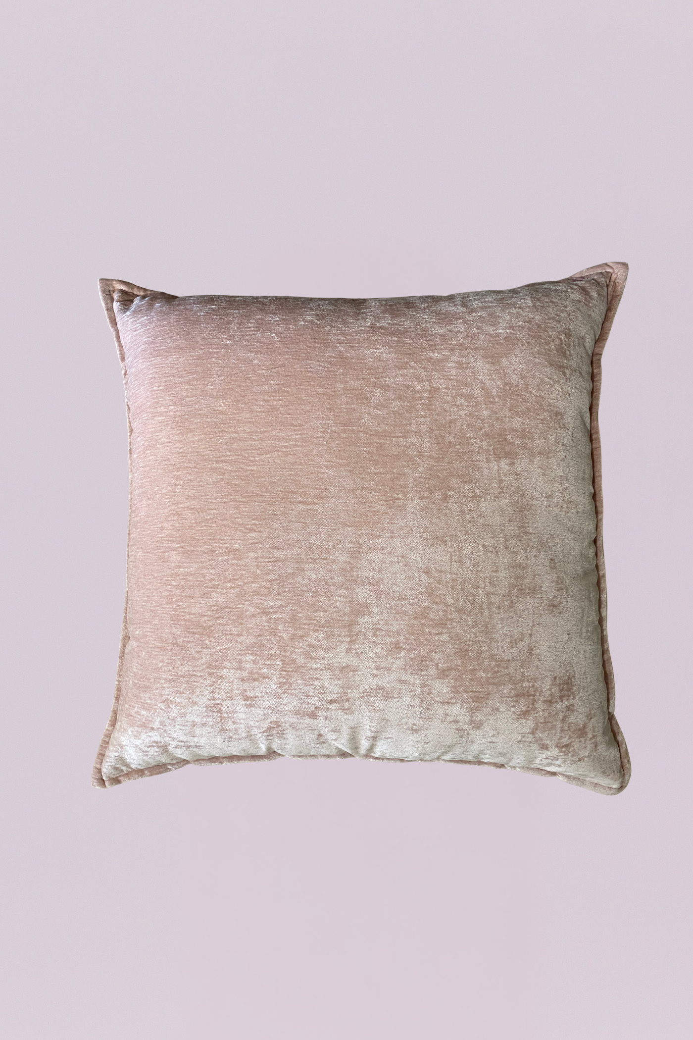 Wrapped in high-luster crushed velvet, this 24x24 accent piece offers a multidimensional glow that shifts from soft blush to warm champagne. Its generous scale and flanged edges provide a structured, designer look while the plush texture invites you to sink in. Perfect for adding a touch of sophisticated romance to a neutral bedding set or a velvet sofa.