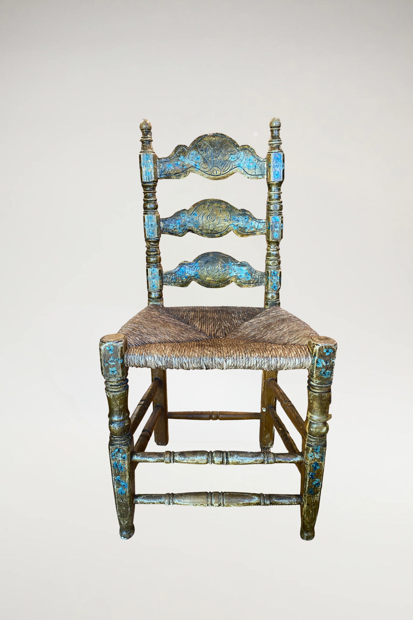 Antique wood chairs featuring beautifully aged carved details and a handwoven rush seat. The natural fiber seat adds texture, durability, and classic charm while providing comfortable support.