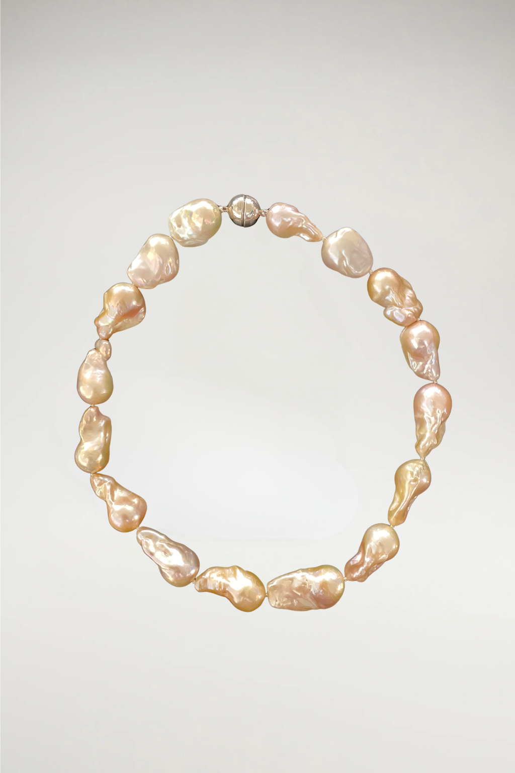 A bold, sculptural statement of oversized baroque pearls. Each stone features a unique, organic silhouette with a rich, high-luster finish. Completed with a polished silver magnetic orb clasp for a modern, sophisticated touch.