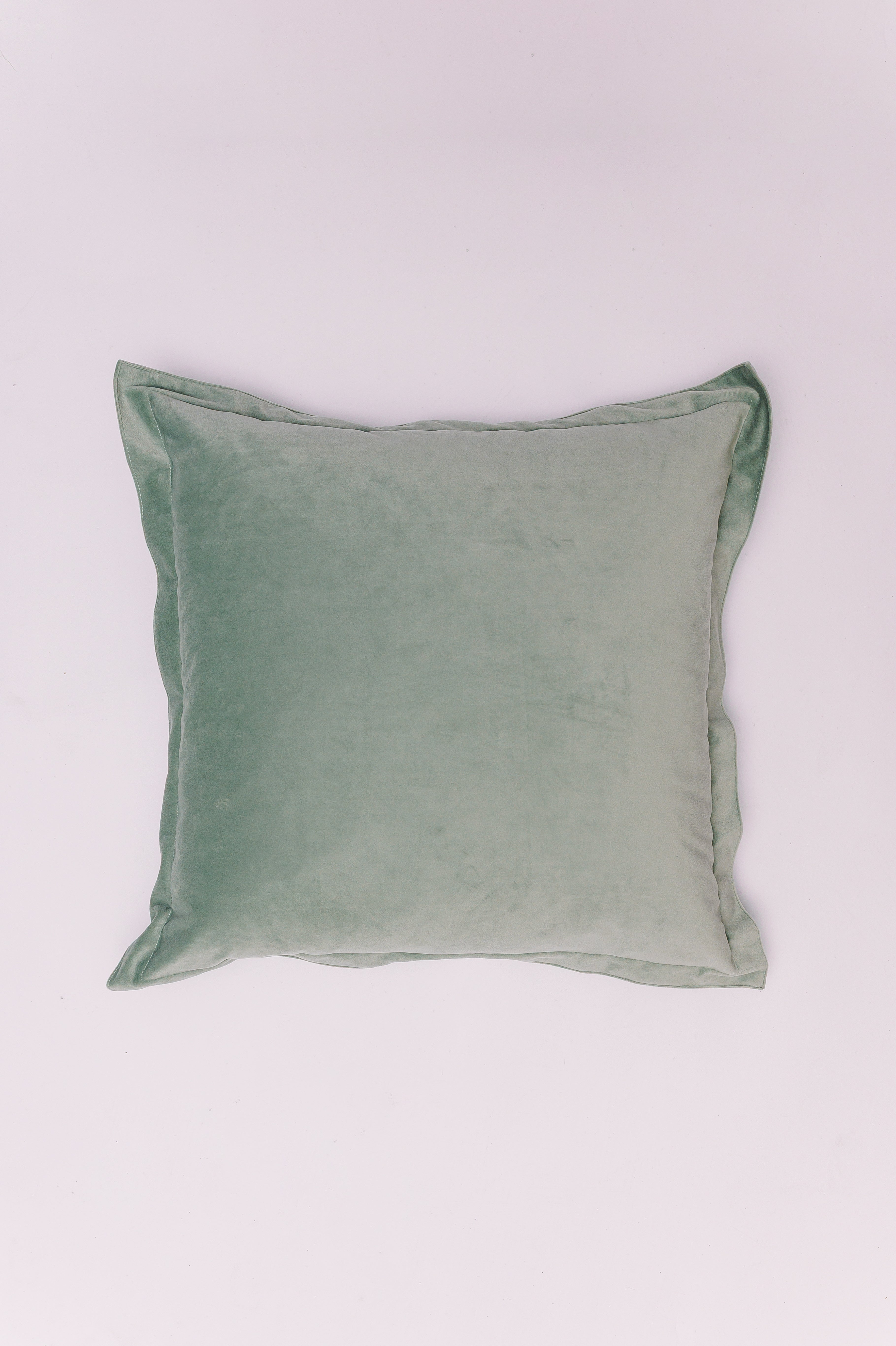 Introduce a touch of serene color and irresistible softness. This pillow is crafted from a plush, high-quality velvet in a dusty mint green hue. Its simple, solid design and elegant knife-edge finish emphasize the luxurious texture of the fabric, allowing the subtle sheen and deep color saturation to become the focal point. This piece is a versatile must-have for layering, offering a calming, sophisticated pop of color.