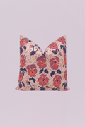 A painterly and romantic accent pillow showcasing large, stylized pansy florals in vibrant coral, mauve, and purple tones against a blush-pink, subtly speckled background. This artistic floral print brings a lush, feminine touch to your decor.