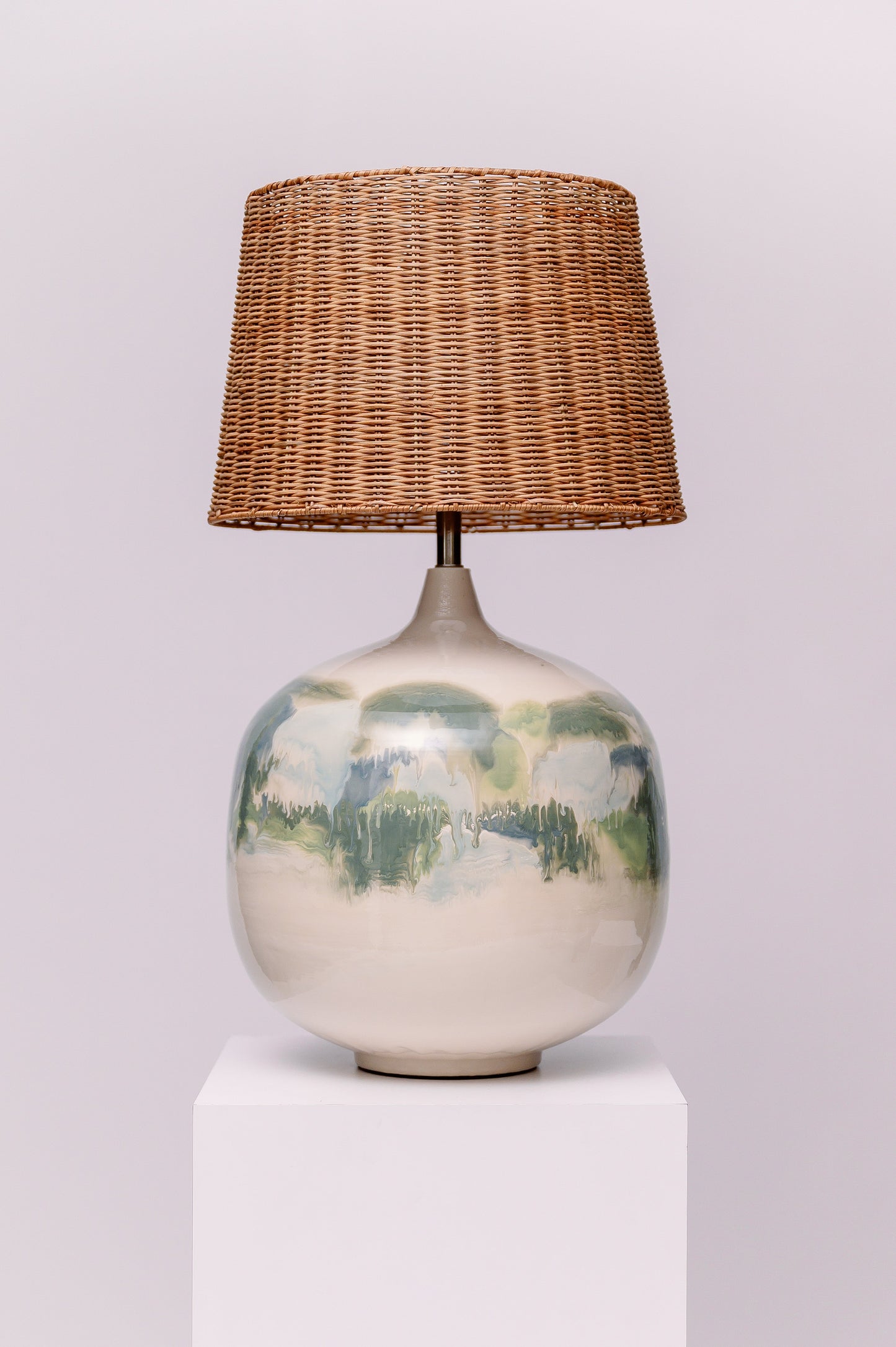 Bring the calm of nature indoors with the Whispering Grove Table Lamp. Featuring a hand-glazed ceramic base that evokes misty forests and serene reflections, each piece feels like a painted daydream. The woven rattan shade adds an earthy, tactile contrast—perfect for grounding modern boho, coastal, or minimalist interiors.