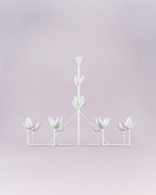 Crafted entirely in matte white, the light cups are sculpted to resemble opening lotus or tulip blossoms, lending the piece a distinct botanical and organic aesthetic. Its simple color palette and symmetrical framework make it a versatile, elegant statement piece suitable for contemporary, minimalist, or feminine interiors.